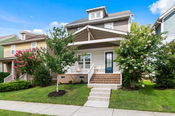 Beautiful suburban home with a landscaped yard and welcoming porch.