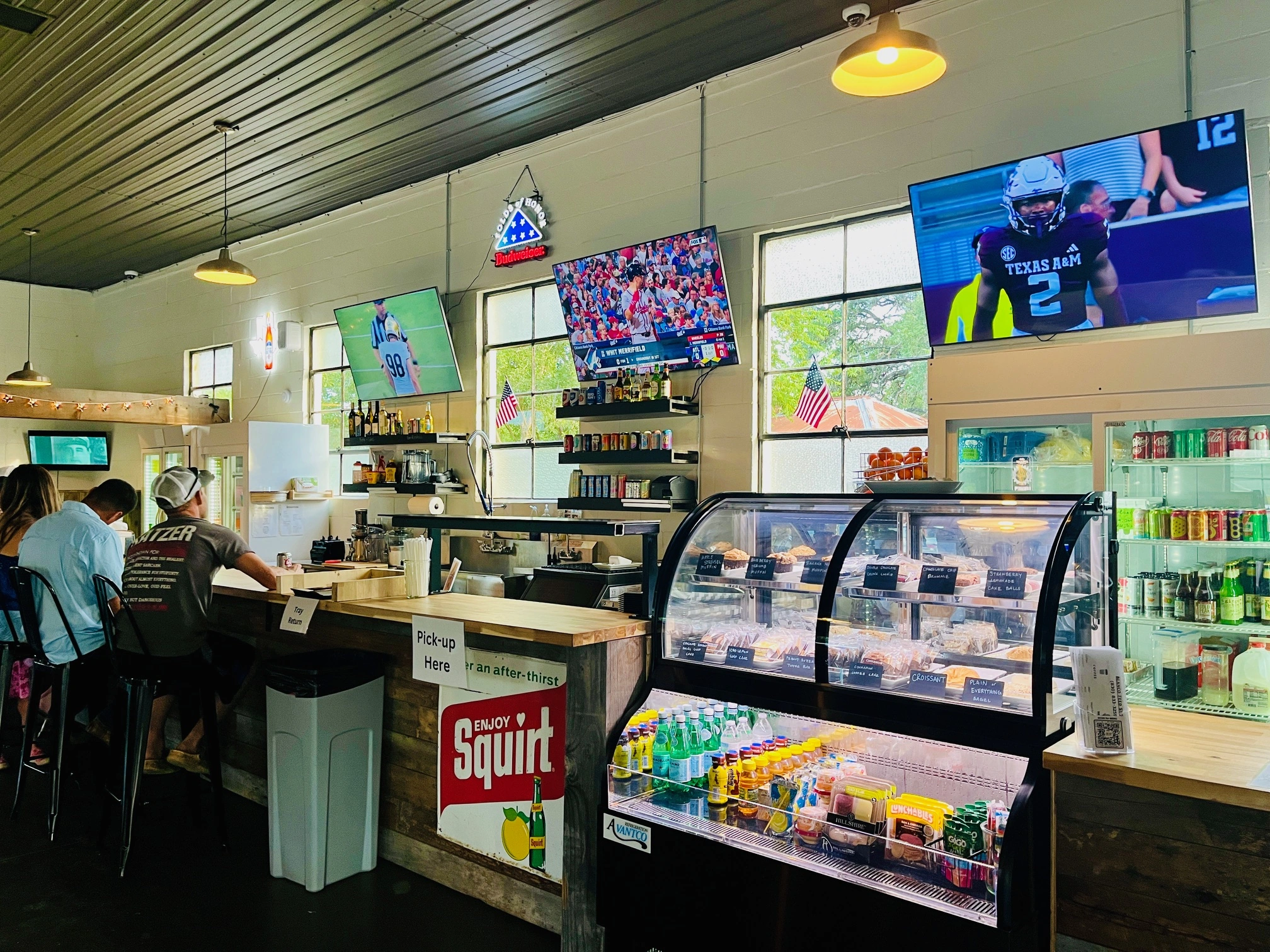 Three large TVs over the bar area at the Blanco Feed Store