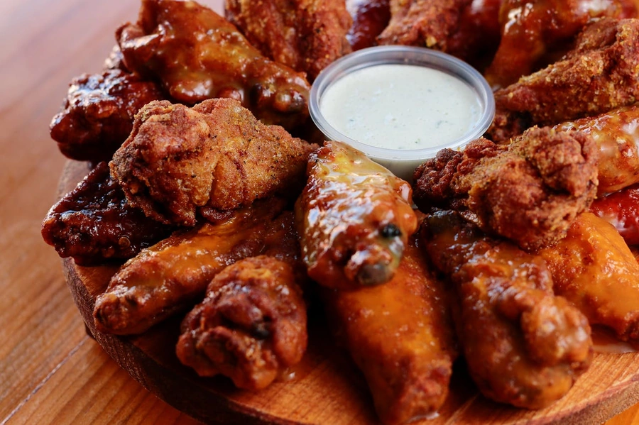 Dish of chicken wings around a dipping sauce
