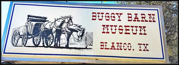 A painted mural on the side of a building. The mural depicts a horse-drawn carriage with the text "BUGGY BARN" and "ELANCO, TX" below it.