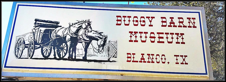 A painted mural on the side of a building. The mural depicts a horse-drawn carriage with the text "BUGGY BARN" and "ELANCO, TX" below it.