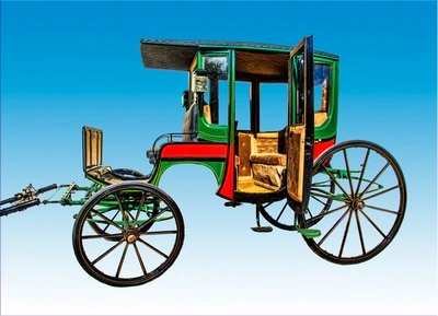 A colorful, vintage carriage with an ornate, wooden body and large spoke wheels. The carriage has a green and red paint scheme with gold accents, giving it an antique and decorative appearance.