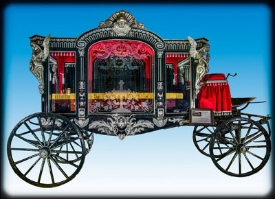 An ornate, elaborately decorated red and gold carriage with intricate carvings and decorations. The carriage appears to be a historic horse-drawn vehicle, possibly from a royal or aristocratic background.