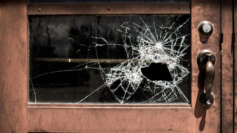 Shattered glass window illustrating burglary and property crime cases