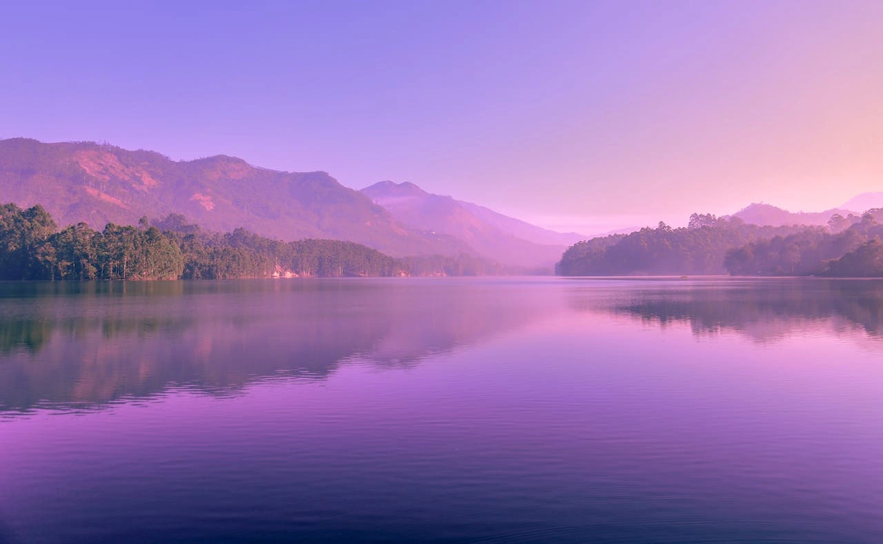 Dawn at lake in mountains with a purple sky