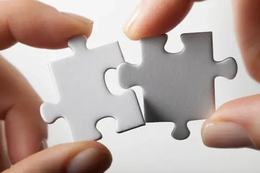 A person trying to fit two puzzle pieces together