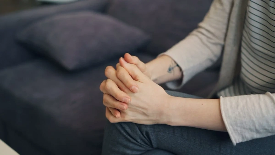 Client seated in comfortable armchair in warm-lit therapy room