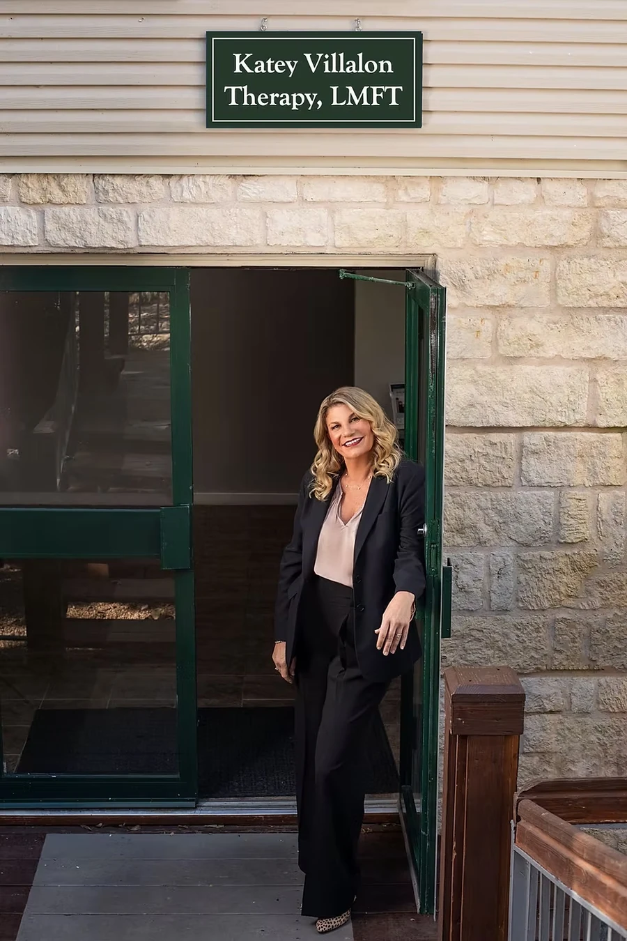 Professional headshot of female therapist in black blazer with friendly smile