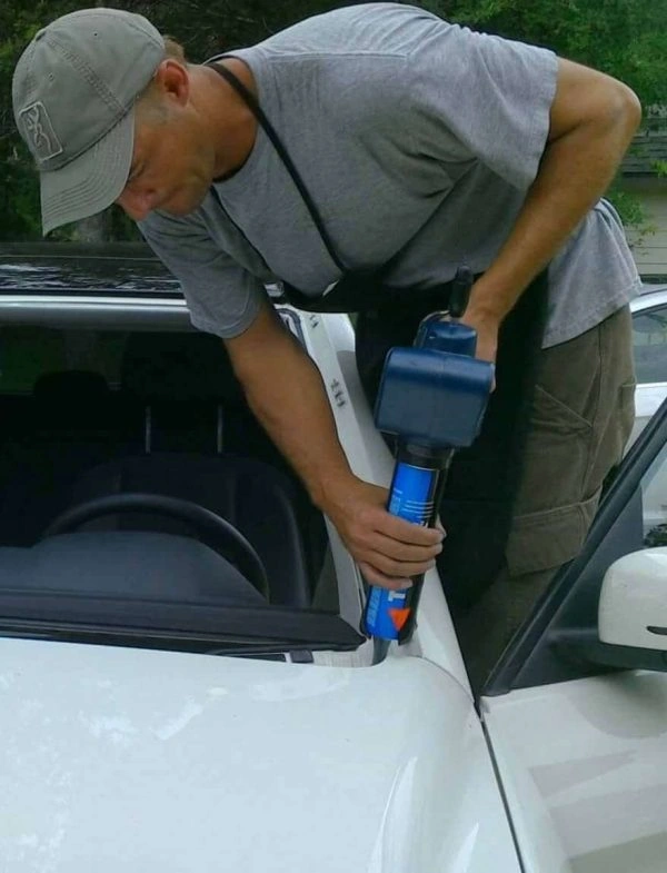 Technician repairing a windshield on a white card
