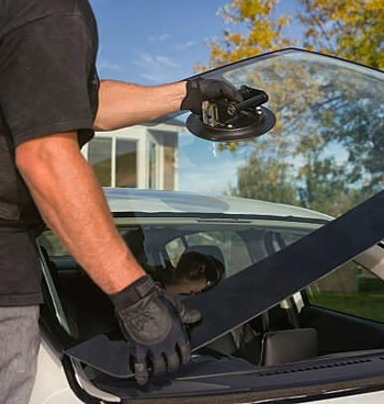 Man replacing a car windshield