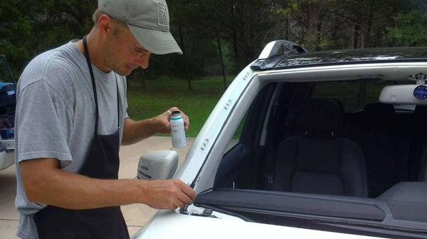 Technician repairing windshield in driveway
