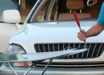 Technician working on a new windshield in front of a car