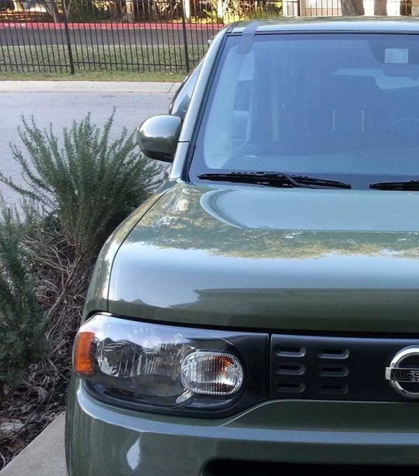 Front of a green Nissan in a driveway