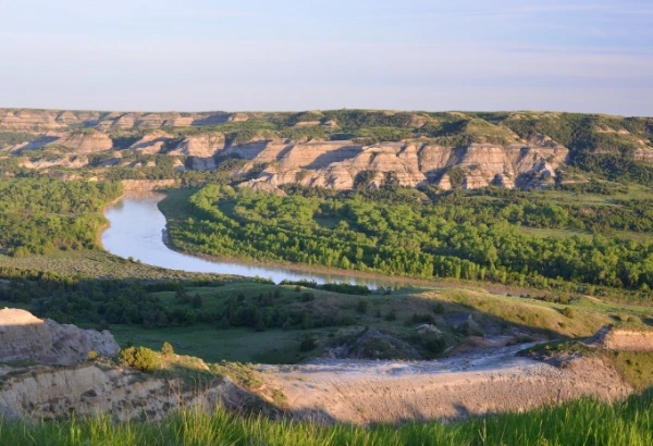 Winding river through a valley with cliffs and a foreground path - landscape image for legacy or estate content