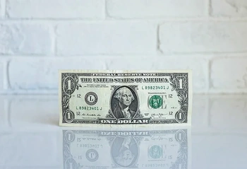 One-dollar bill on a reflective surface symbolizing financial considerations in estate and trust planning