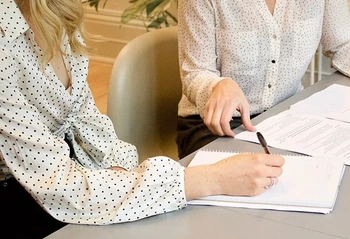 Two people reviewing contract documents