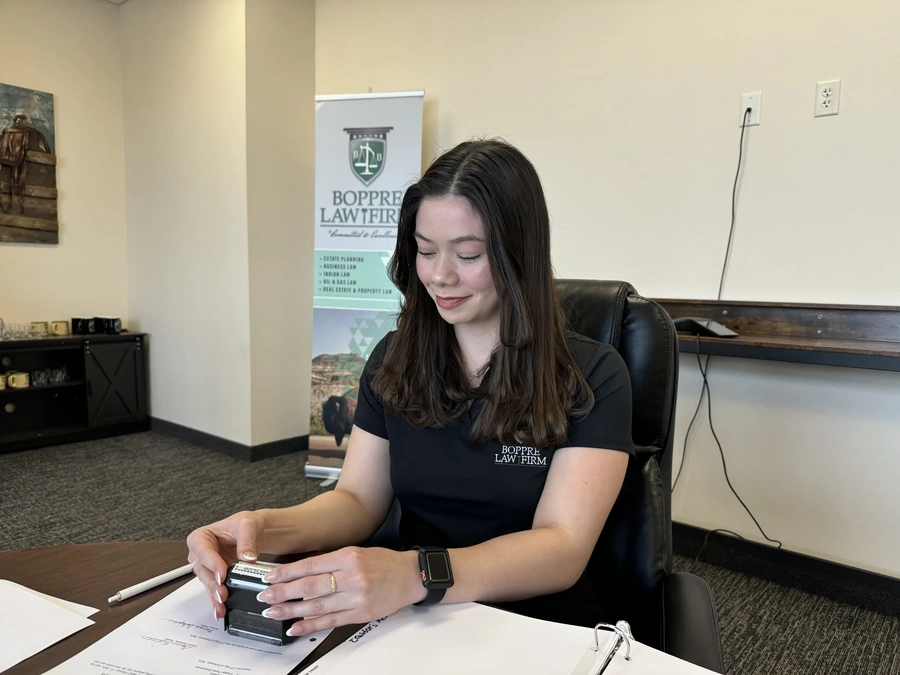 Staff member providing notary services with documents on a table during a community event