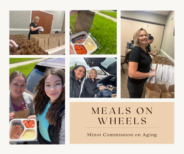 Volunteers packing brown-bag meals and loading a car beside a 'Meals on Wheels' banner for Minot Commission on Aging