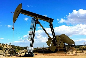Oil pumpjack on a dry site beneath blue sky, illustrating mineral and oil operations