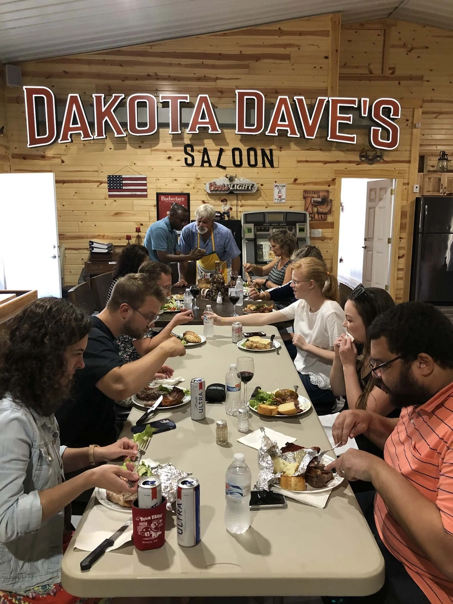 Community meal at Dakota Dave's Saloon around a long table with wood-paneled interior
