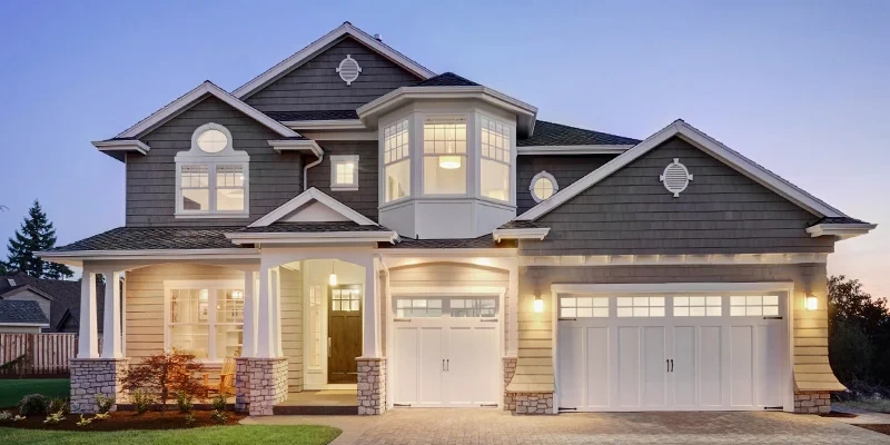 Two-story house with bay window and stone-column porch at dusk, illustrating real estate property law.