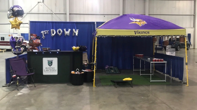Indoor convention area with purple 'Vikings' canopy, silver '1st DOWN' balloons, and a reception desk