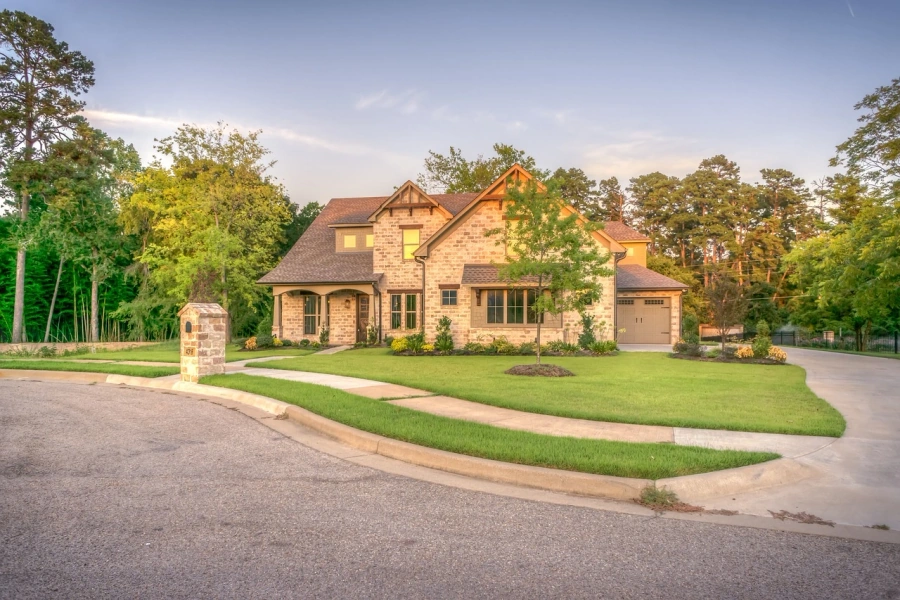 Luxury stone home with professionally landscaped front yard at sunset