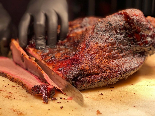 Brisket being cut by a pit master