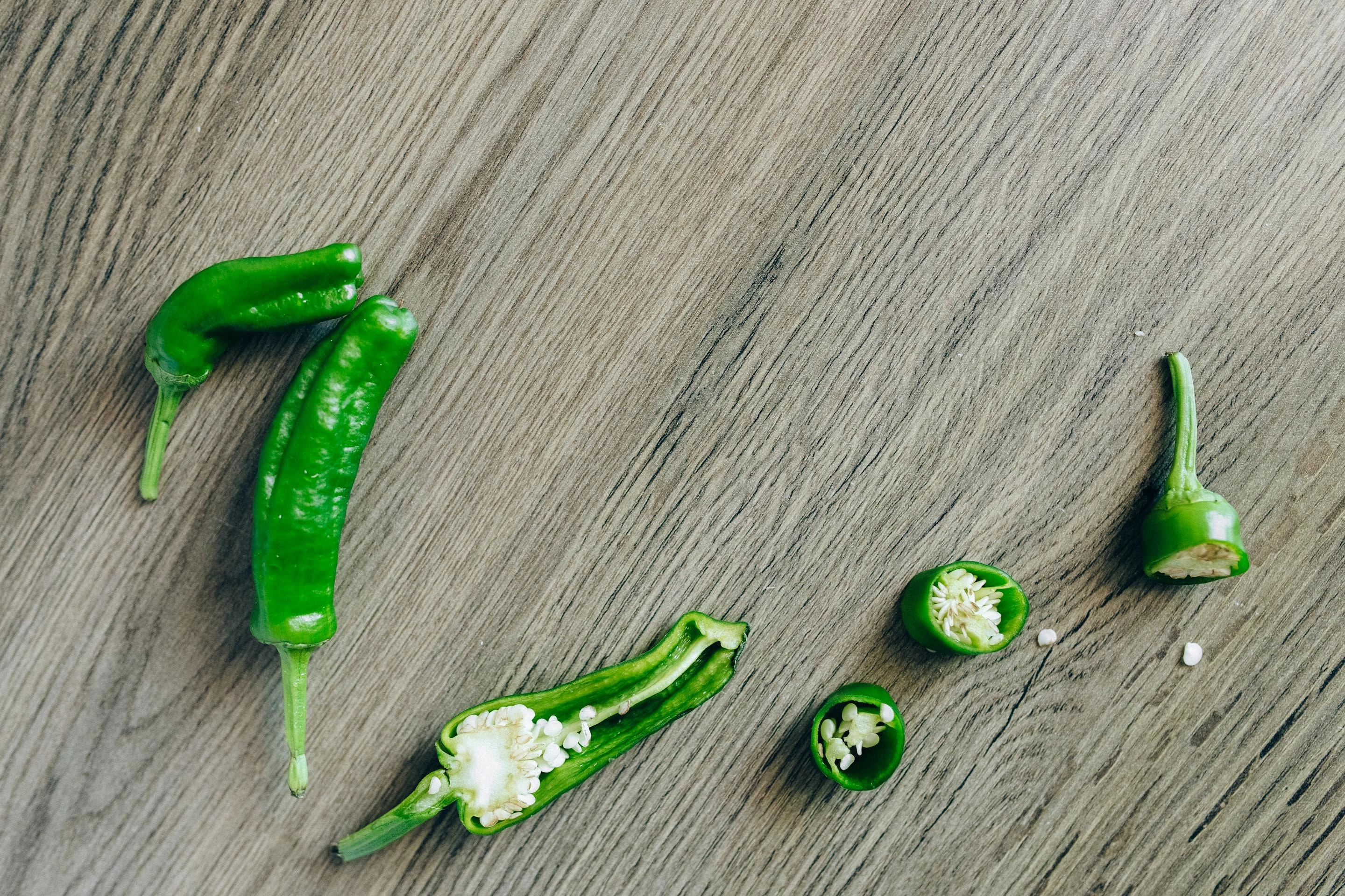 Sliced jalapeños on a wood table