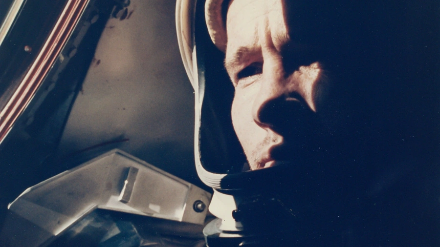 An Apollo-era astronaut working inside a command module.