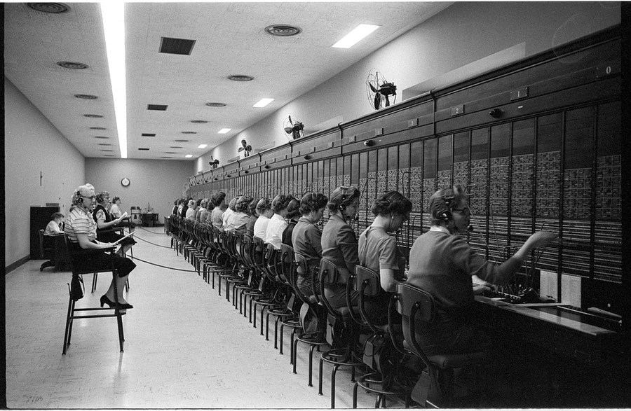 Operators coordinate calls at a 1959 switchboard.
