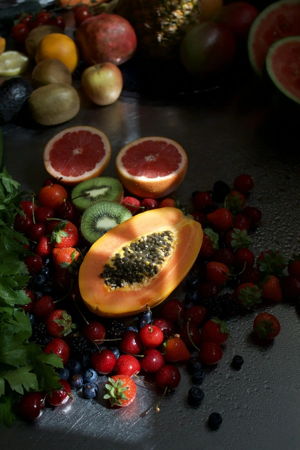 Colorful fruits including papaya, kiwi, grapefruit, and an assortment of berries