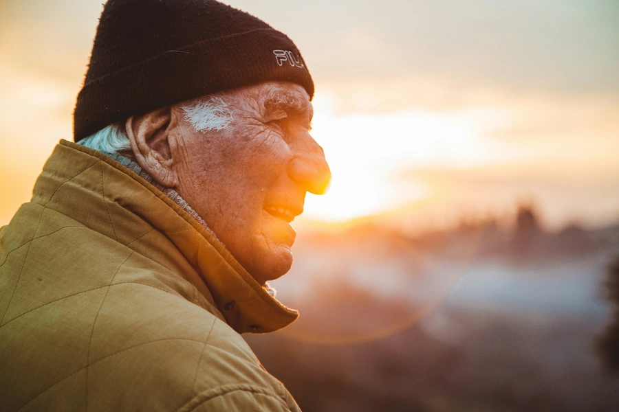 Profile of an elderly man with the sunrise in the background