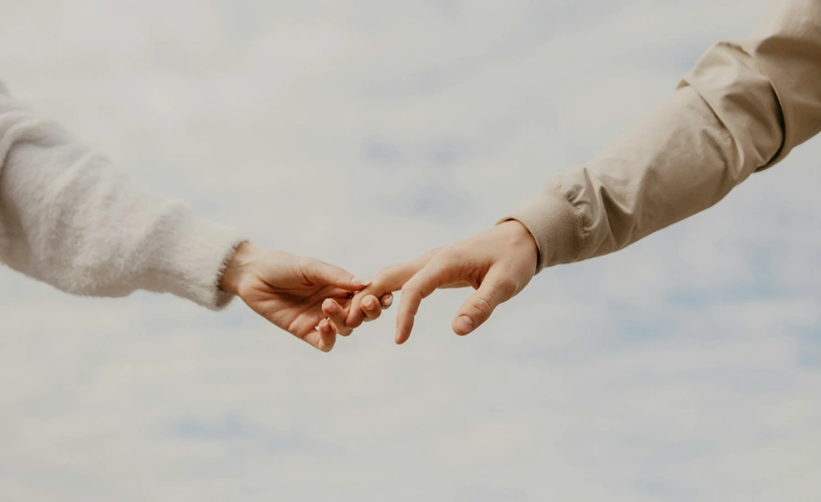People holding hands by their fingers