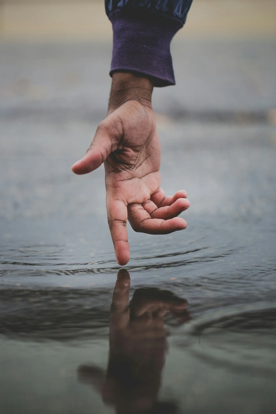 Person touching water with pointer finger