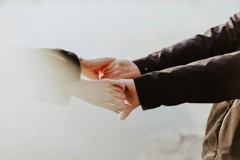 People holding hands facing each other apart, like they are dancing