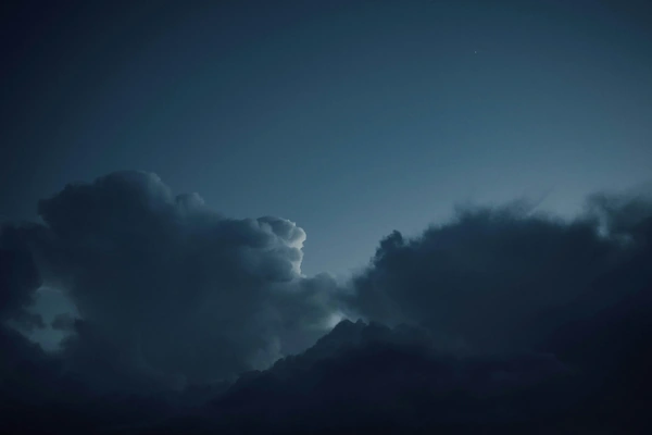 Dark clouds with some light from the sun showing behind them