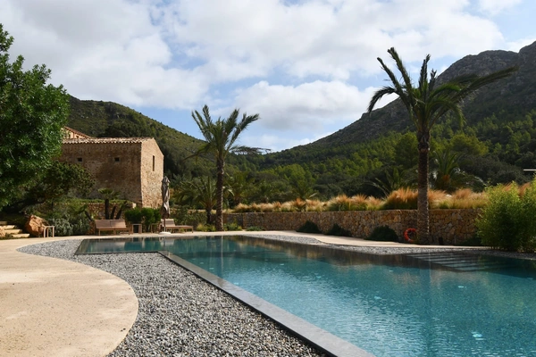 Resort in mountains with palm trees surrounding the pool