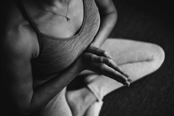 Person sitting in yoga pose in a black and white photo