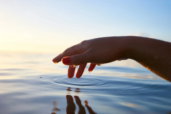 Hand lightly touching the water