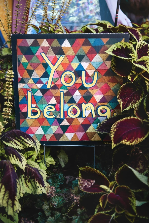 Picture of artwork that says 'You belong' with plants surrounding it