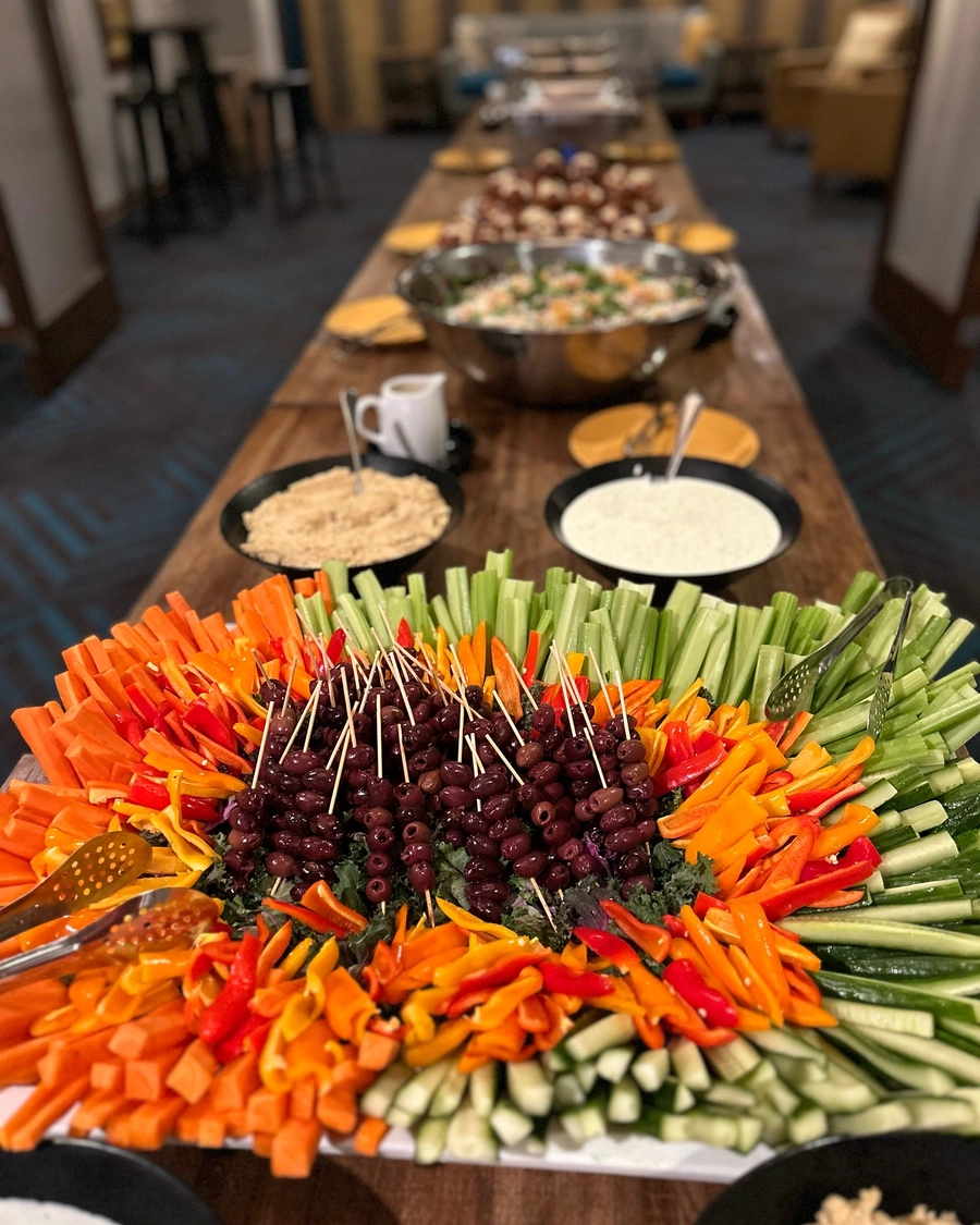 Elegant catering table at Brewtorium with a selection of gourmet appetizers, fresh fruit, and decorative floral arrangements for special events