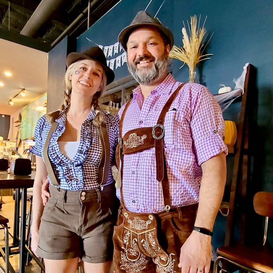 Festive Oktoberfest celebration at Brewtorium featuring Chris Whitney, with traditional German decorations, steins of beer, and guests enjoying the authentic atmosphere