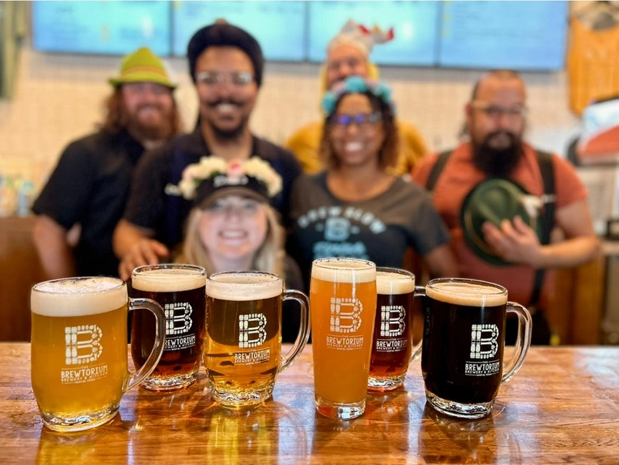 Community gathering at Brewtorium's bar, featuring our extensive selection of draft beers and a welcoming atmosphere for beer enthusiasts