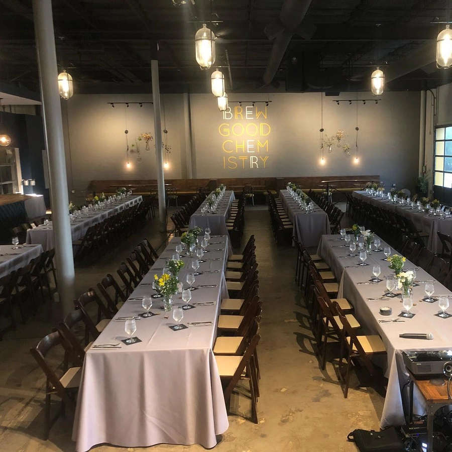 Spacious Brewtorium event space set up for a dinner reception, featuring elegantly arranged tables, ambient lighting, and a welcoming atmosphere for large gatherings
