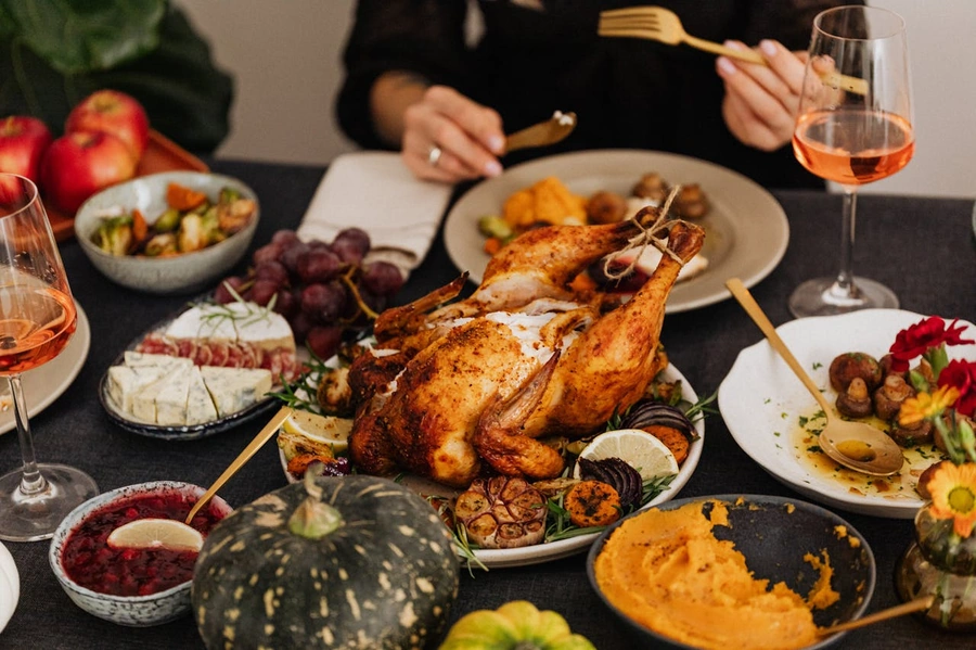 Thanksgiving turkey in the middle of a table with all the Thanksgiving sides