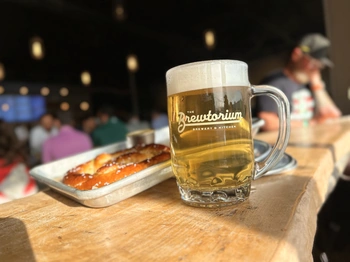 A mug of Brewtorium craft beer and a pretzel at happy hour