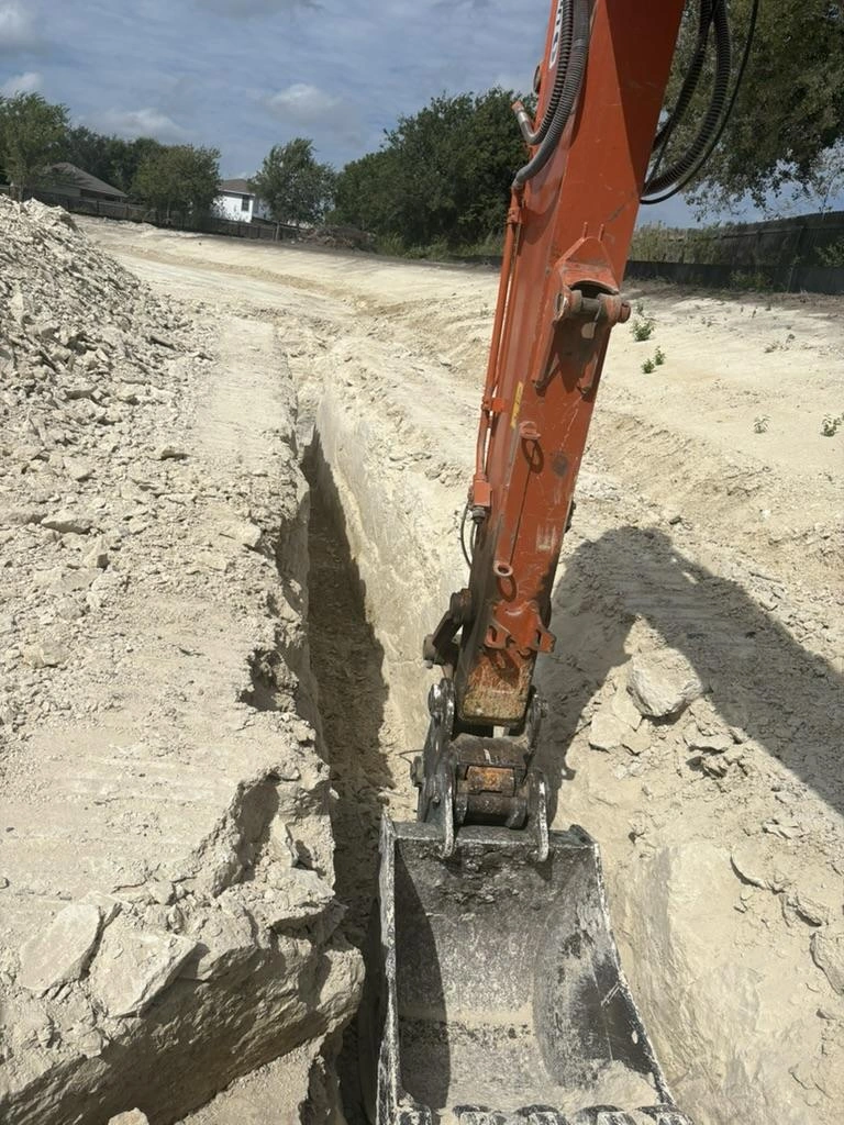 Excavator digging a utility trench at Pflugerville Marketplace