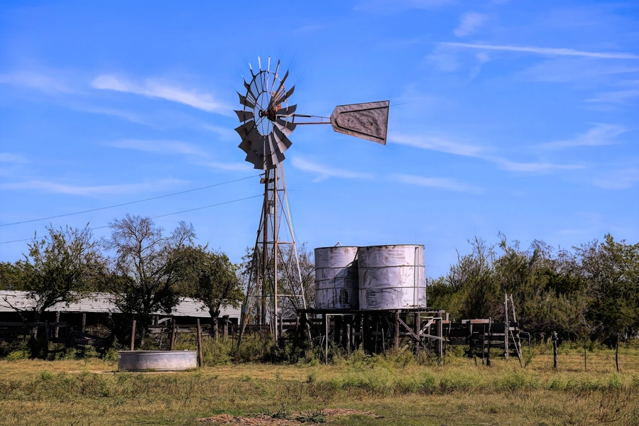 Windmill and water tanks on clear day on a Texas Ranch