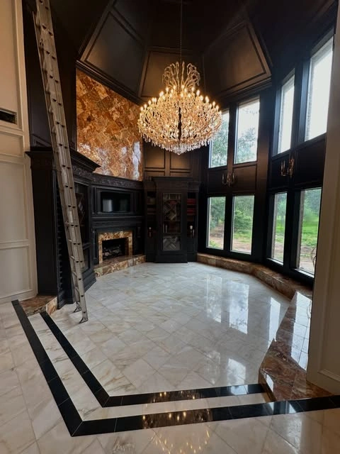 Polished marble floors with custom inlay, dramatic stone accents, and hand-crafted millwork
